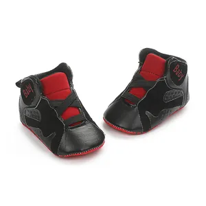 Detailed view of black and red infant basketball sneakers with soft anti-slip soles