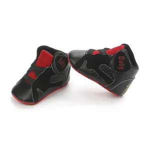 Detailed view of black and red infant basketball shoes with soft non-slip soles.
