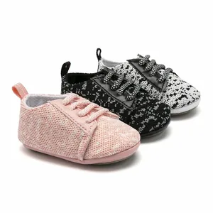 Side view detail of breathable knitted baby walking shoes in pink, black and white
