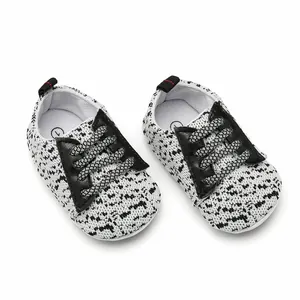 Detailed view of breathable baby sneakers with black and white knitted pattern