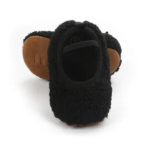 Detailed view of black fuzzy fleece baby walking shoes with elastic strap