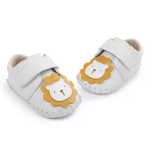 Gros plan de chaussures bébé blanches avec lion mignon et semelle en caoutchouc