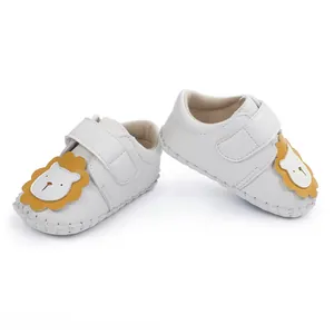 Vue détaillée de chaussures de marche blanches pour bébé avec lion en dessin animé