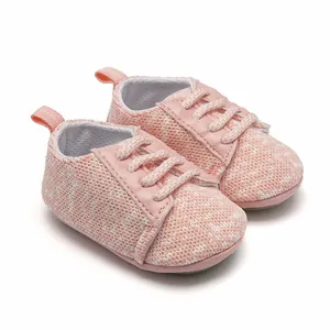 Detailed macro view of pink knitted baby walking shoes featuring soft non-slip rubber soles