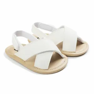 Detailed close-up view of white cross-strap baby sandals featuring soft non-slip soles.