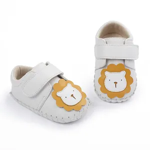 Vue détaillée de chaussures de marche pour bébé blanches avec lion mignon