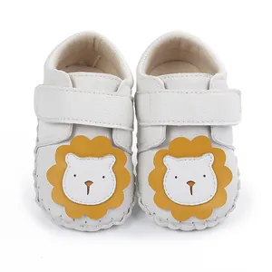 Chaussures bébé blanches souples avec un joli motif de lion jaune pour l'apprentissage