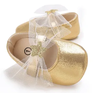 Detailansicht goldene Baby-Prinzessinenschuhe mit Netzschleife und Glitzerstern