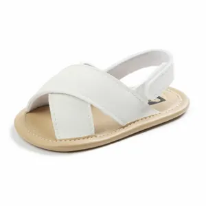 Close-up view of white cross-strap baby sandals featuring a soft non-slip walking sole
