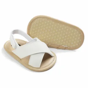 Detailed view of baby sandals with soft non-slip sole and white cross straps