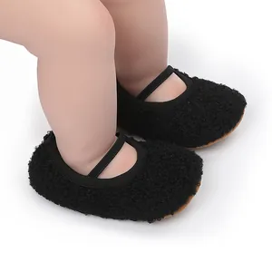 Close-up of soft black fuzzy baby walking shoes with elastic strap on mannequin feet