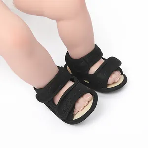 Close-up of black baby summer walking shoes with double velcro straps on white background