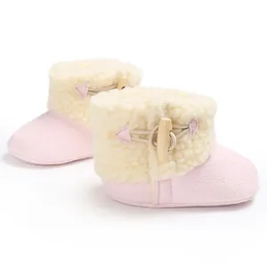 Side detail of pink baby snow boots showing soft fleece lining and wooden toggle fastener