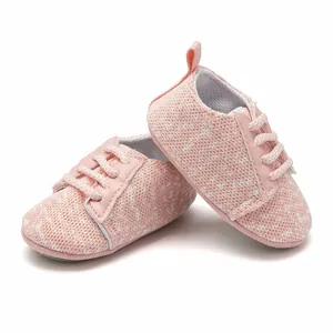 Detailed macro view of pink knitted baby sneakers featuring soft fabric and non-slip rubber soles