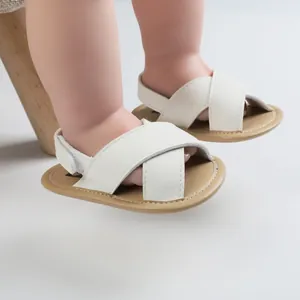Close-up detail of white baby summer walking sandals with soft soles on infant feet