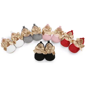 Vista detallada de zapatos de princesa para bebé en varios colores con lazos dorados