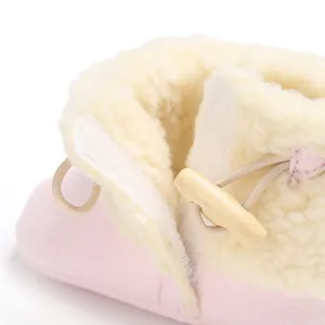 Detail of baby winter snow boot with warm fleece lining and wooden toggle button