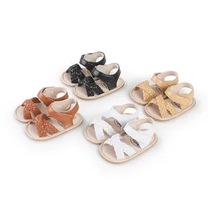 Detailed shot of baby girl summer sandals in black, brown, white, and tan with braided straps