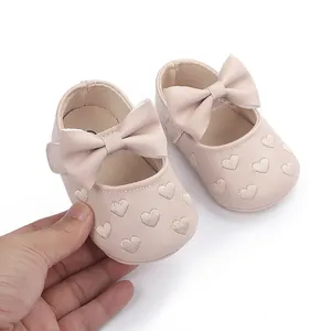 Detailansicht rosa Baby-Prinzessinenschuhe mit großen Schleifen und Herzstickerei