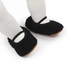 Gedetailleerd overzicht van warme zwarte fleece babyschoentjes met zachte bruine zool