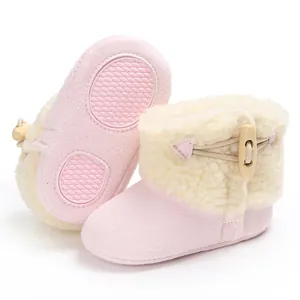 Detail of pink infant snow boots showing warm fleece lining and non-slip rubber sole patches