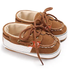 Nahaufnahme von braunen Wildleder-Babyschuhen mit weicher Sohle und Schnürsenkeln