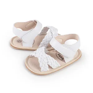 Close-up of white braided baby sandals with adjustable velcro straps for infants