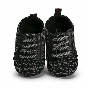 Close-up front view of black and grey knitted baby walking shoes with soft rubber soles
