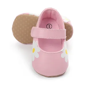 Detailed view of pink baby walker shoes with white daisy print and non-slip soles.