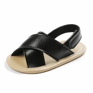 Detailed close-up view of black leather baby sandals with soft soles and cross straps for summer