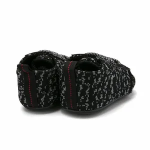 Rear view detail of black and white knit baby walker shoes with red stitching on heel tab.