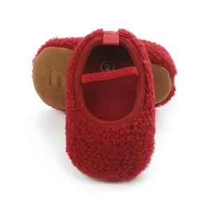 Close-up detail of red sherpa baby shoes featuring a soft sole and secure elastic strap