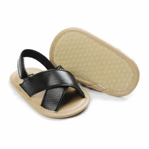 Detailed view of baby sandals with non-slip soft soles and stylish black cross straps.