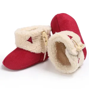 Close-up of red baby snow boots with cozy faux shearling lining and wooden horn button