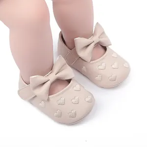 Detaillierte Ansicht beiger Baby-Lauflernschuhe mit Schleife und Herzstickerei