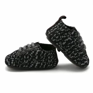 Detailed view of breathable knit baby sneakers with anti-slip rubber soles in black