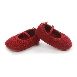 Close-up of red fuzzy Sherpa baby walking shoes with elastic strap for infant comfort