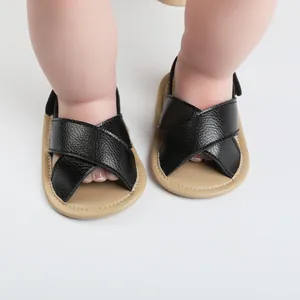 Detailed view of black cross-strap baby sandals featuring a soft non-slip rubber sole