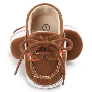 Nahaufnahme von braunen Wildleder-Lauflernschuhen für Babys mit weichen weißen Sohlen