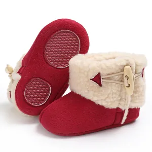 Detailed view of red baby winter boots with faux fur trim and anti-slip rubber sole