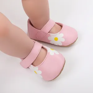 Detail of pink baby pre-walker shoes with white daisy print and velcro strap closure.