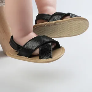 Detailed close-up of black leather infant sandals showing non-slip soft sole texture