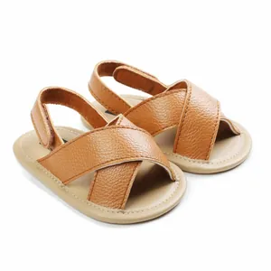 Close-up of stylish brown faux leather baby sandals with soft soles for infant pre-walkers