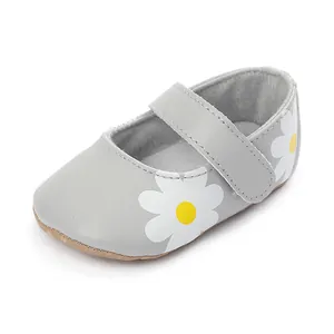 Close-up detail of grey baby walking shoe with charming white daisy print and adjustable strap