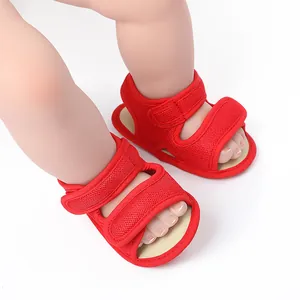 Close-up detail of red breathable mesh infant walking sandals with dual Velcro strap closures