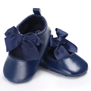 Λεπτομερής κοντινή λήψη σκούρων μπλε βρεφικών παπουτσιών με μεγάλο διακοσμητικό φιόγκο