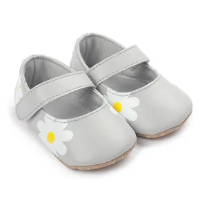 Close-up of grey infant walking shoes featuring a white and yellow daisy floral pattern
