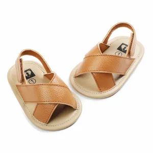 Top view of brown faux leather baby sandals with cross straps and soft beige soles