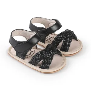 Close-up detail of black woven leather straps on baby girl summer walking sandals