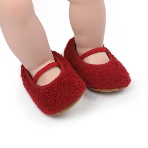 Close-up of red fuzzy baby walking shoes with elastic strap on white background